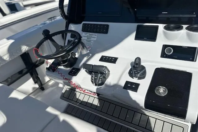 Slide: The Image of 2026 Tidewater 302 CC Adventure boat console with steering wheel and controls. - 13