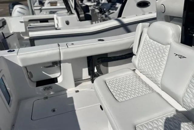 Slide: The Image of 2026 Tidewater 302 CC Adventure boat interior with white quilted seating. - 9