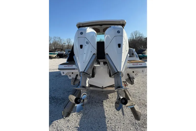 Slide: The Image of 2026 Monterey Elite 30 OB boat with dual outboard engines, parked on gravel. - 4