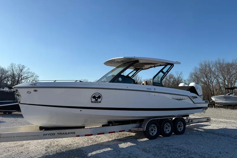 Slide: The Image of 2026 Monterey Elite 30 OB boat on trailer under clear blue sky. - 7
