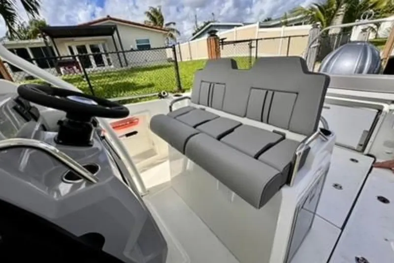 Slide: The Image of 2023 Jeanneau Leader 7.5 CC S3 boat interior with gray seating and steering wheel. - 5