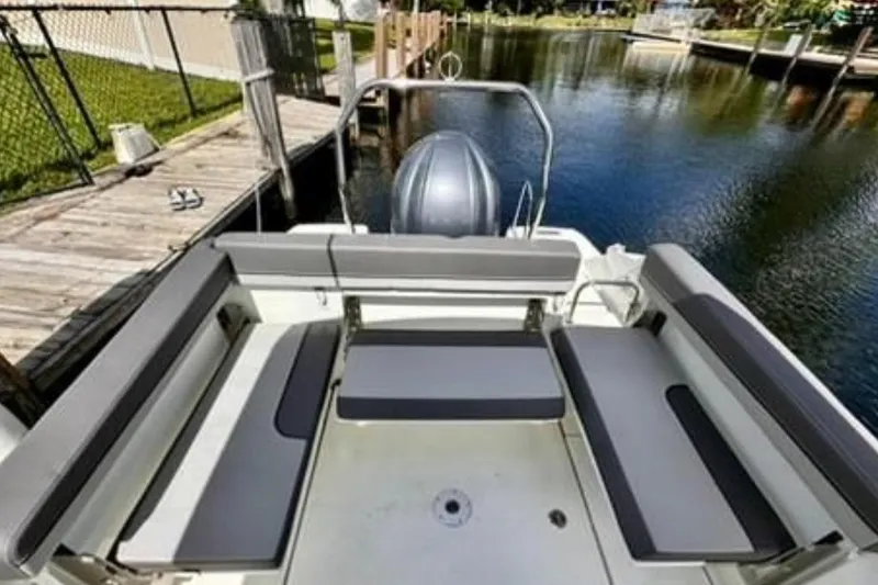 Slide: The Image of 2023 Jeanneau Leader 7.5 CC S3 boat interior with cushioned seating by the water. - 6