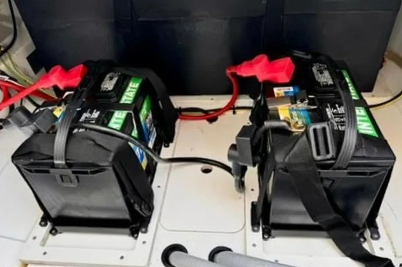 Slide: The Image of Dual batteries in a 2023 Jeanneau Leader 7.5 CC S3 boat, secured with straps. - 7