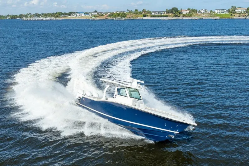 The Image of 2023 Scout 355 LXF boat making a sharp turn on open water. - 0