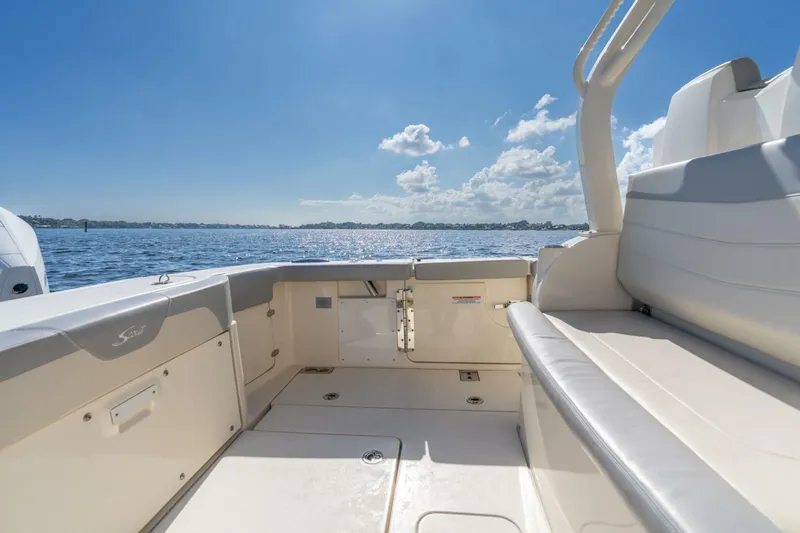Slide: The Image of 2023 Scout 355 LXF boat interior with seating, overlooking calm waters and blue sky. - 16