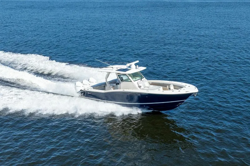 Slide: The Image of 2023 Scout 355 LXF boat cruising on open water, showcasing sleek design and performance. - 2