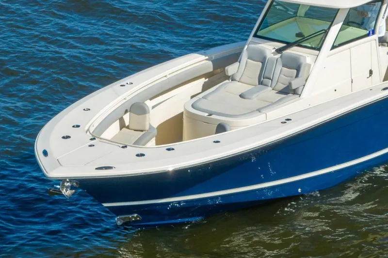 Slide: The Image of 2023 Scout 355 LXF boat with sleek design on blue water. - 4