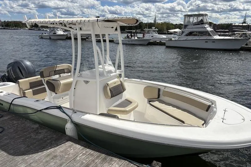 Slide: The Image of 2019 Tidewater 210 CC Adventure boat docked by the water on a sunny day. - 3