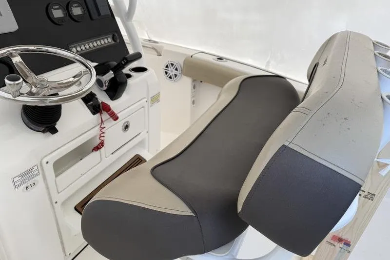 Slide: The Image of 2019 Tidewater 210 CC Adventure boat interior with steering wheel and cushioned seating. - 8