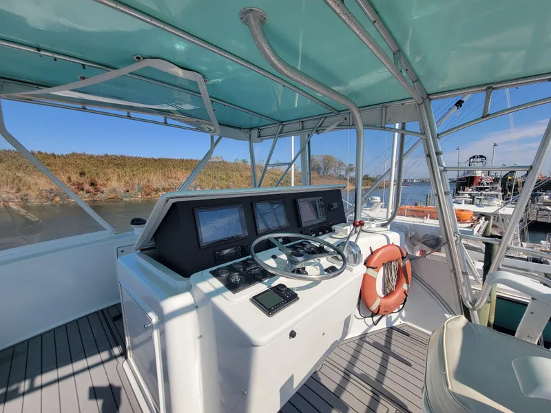 Slide: The Image of Helm of 1998 Custom Carolina 45 Willis Boatworks, featuring navigation equipment and steering wheel. - 13