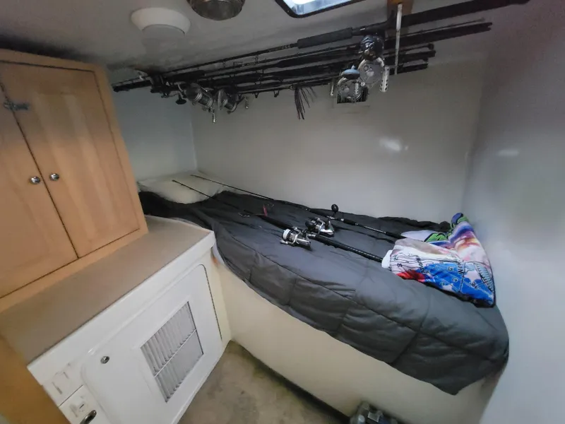 Slide: The Image of Interior cabin of 1998 Custom Carolina 45 Willis Boatworks with fishing rods and cozy bedding. - 25