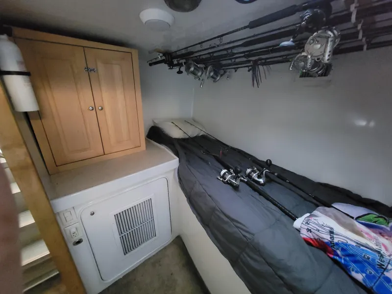 Slide: The Image of 1998 Custom Carolina 45 Willis Boatworks cabin with fishing rods and storage. - 26