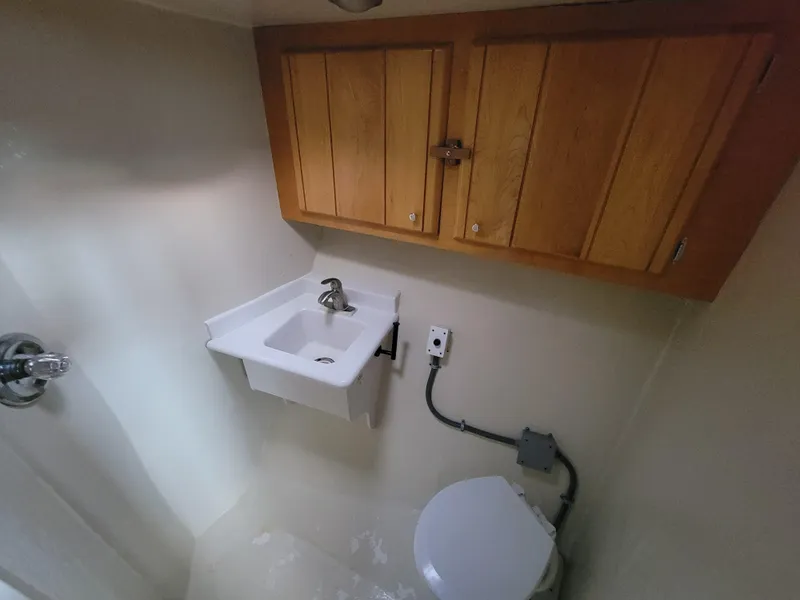 Slide: The Image of Bathroom interior of 1998 Custom Carolina 45 Willis Boatworks, featuring sink and wooden cabinets. - 31