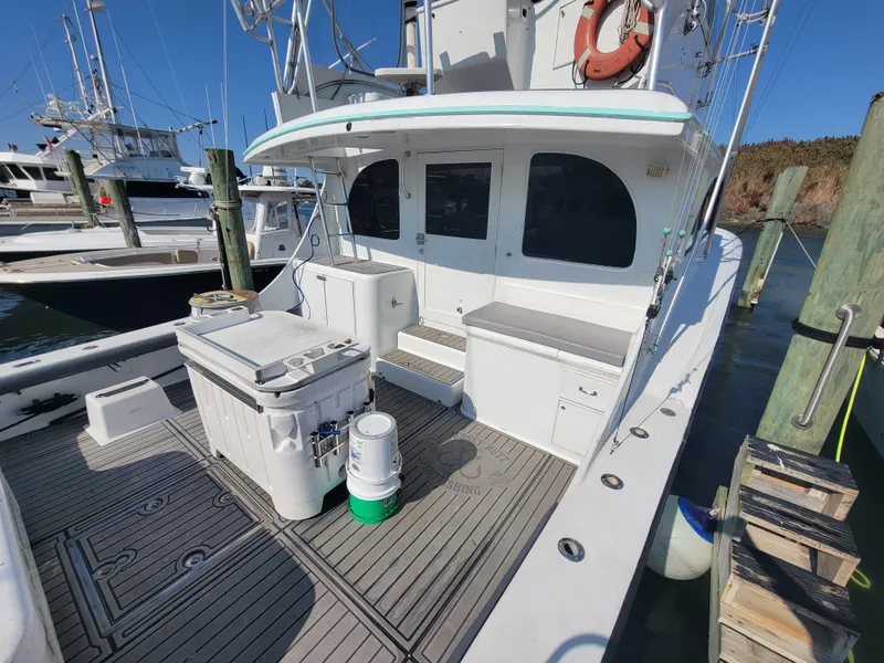 Slide: The Image of Custom Carolina 45 Willis Boatworks 1998, docked, featuring spacious deck and fishing equipment. - 9