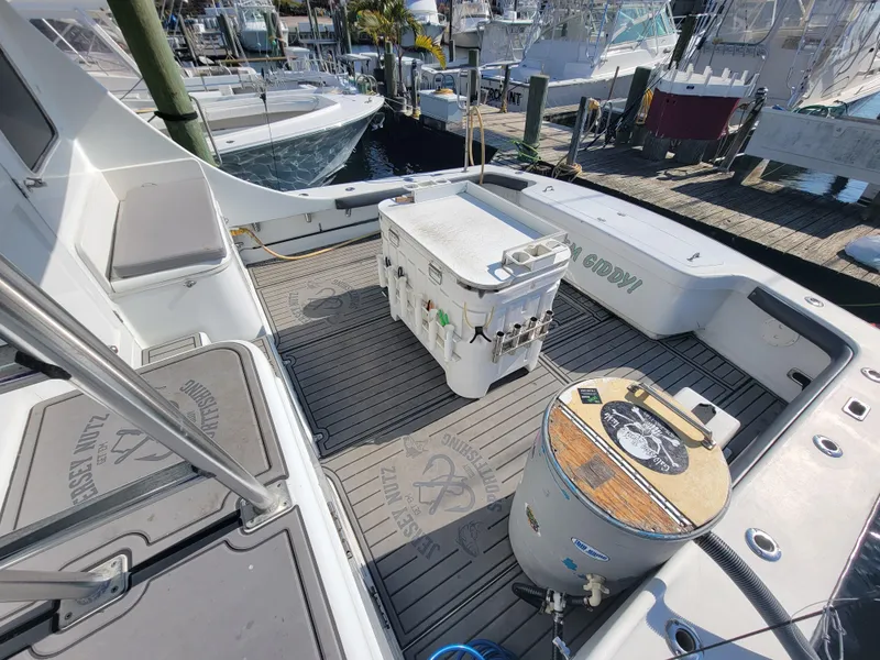 Slide: The Image of 1998 Custom Carolina 45 Willis Boatworks deck with fishing gear and cooler. - 19