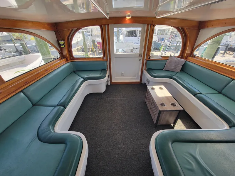 Slide: The Image of Luxurious interior of 1998 Custom Carolina 45 Willis Boatworks with green seating and wooden accents. - 20
