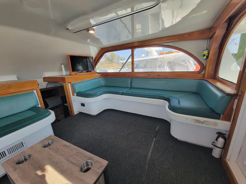 Slide: The Image of Interior of 1998 Custom Carolina 45 Willis Boatworks with teal seating and wood accents. - 22