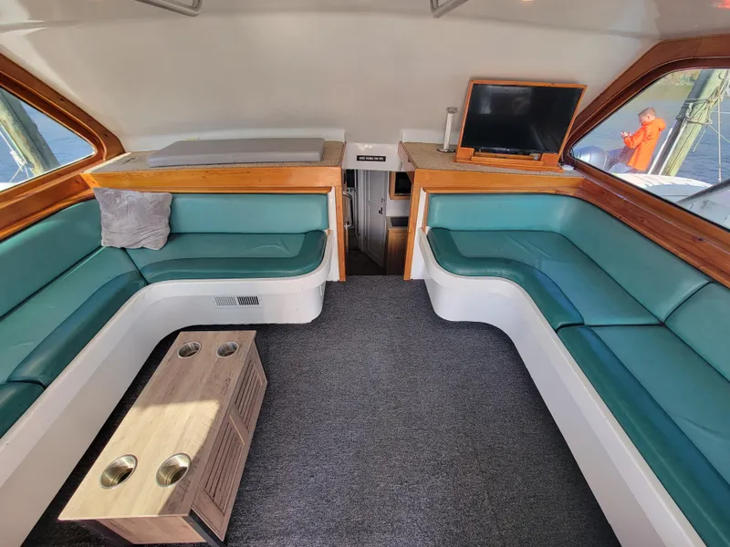 Slide: The Image of Interior of 1998 Custom Carolina 45 Willis Boatworks with teal seating and a small table. - 23