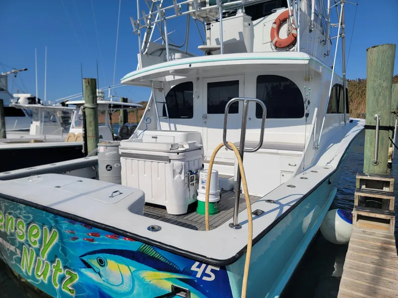 Slide: The Image of 1998 Custom Carolina 45 Willis Boatworks docked, featuring vibrant marine artwork on the stern. - 6