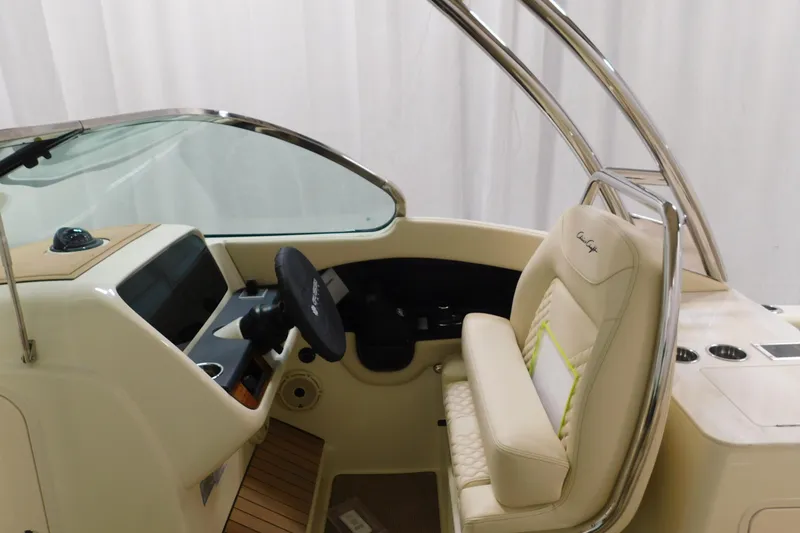 Slide: The Image of 2023 Chris-Craft Calypso 28 boat interior with steering wheel and cushioned seating. - 11