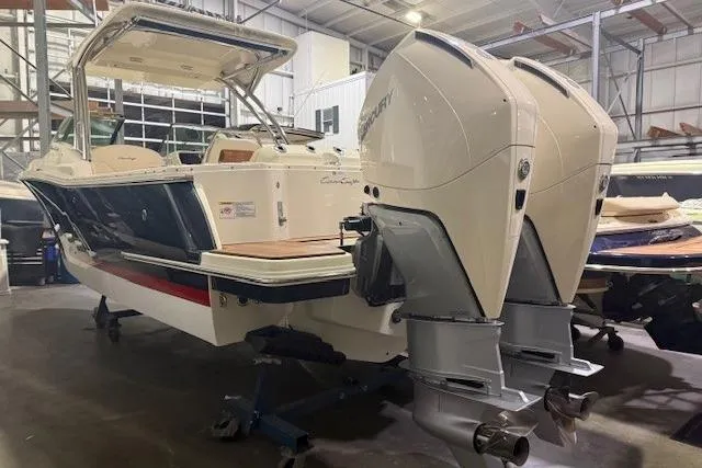 Slide: The Image of 2023 Chris-Craft Calypso 28 boat with dual outboard engines in a storage facility. - 12