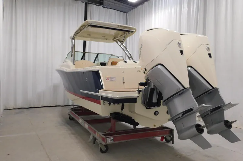 Slide: The Image of 2023 Chris-Craft Calypso 28 boat in showroom, featuring sleek design and elegant navy hull. - 7