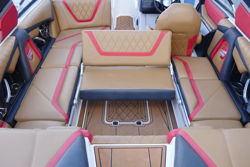 Slide: The Image of 2017 Tigé RZX2 boat interior with tan and red seating, featuring diamond stitching. - 10