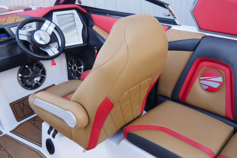 Slide: The Image of 2017 Tigé RZX2 boat interior with tan and red seating, modern dashboard, and steering wheel. - 15