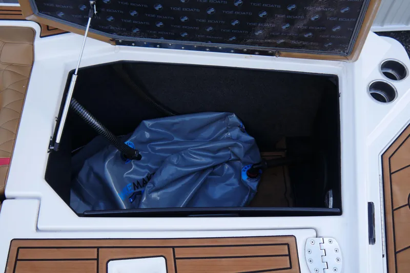 Slide: The Image of 2017 Tigé RZX2 boat storage compartment with ballast bag and cup holders. - 16