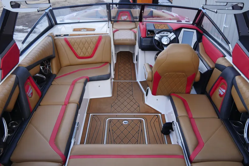 Slide: The Image of 2017 Tigé RZX2 boat interior with tan and red seating, modern dashboard, and stylish flooring. - 9