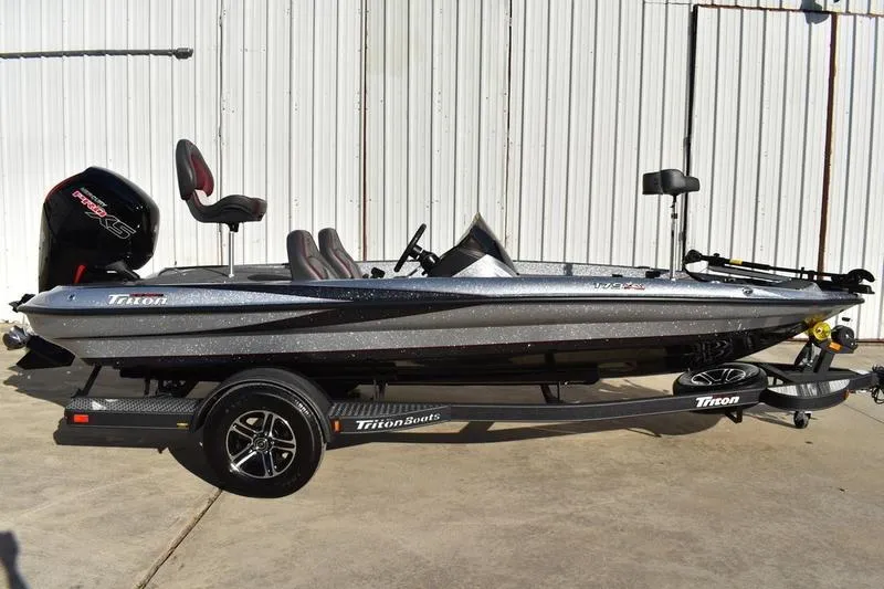 The Image of 2026 Triton 179 TrX bass boat on trailer, silver finish, parked outdoors. - 0