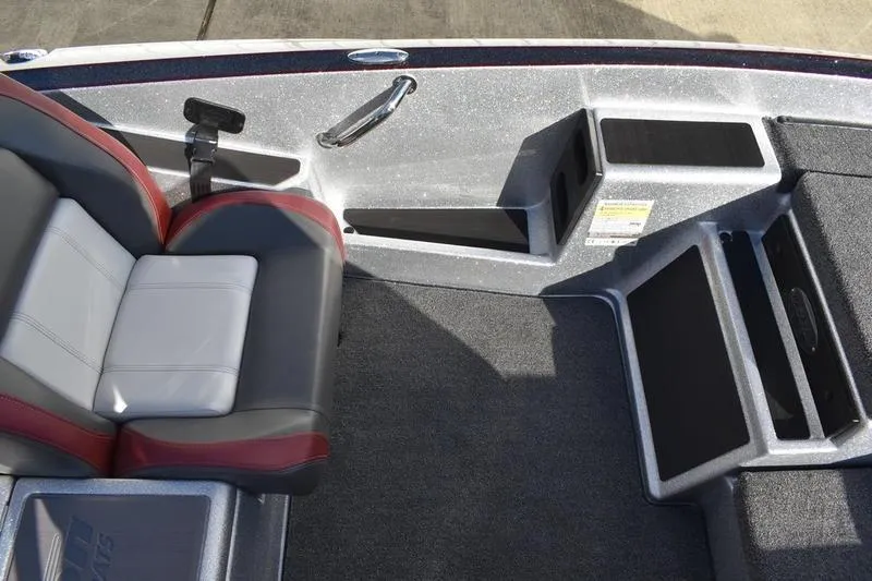 Slide: The Image of 2026 Triton 179 TrX boat interior with gray and red seating, carpeted flooring, and storage compartments. - 17