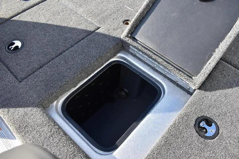 Slide: The Image of 2026 Triton 179 TrX boat storage compartment with carpeted deck and open hatch. - 31