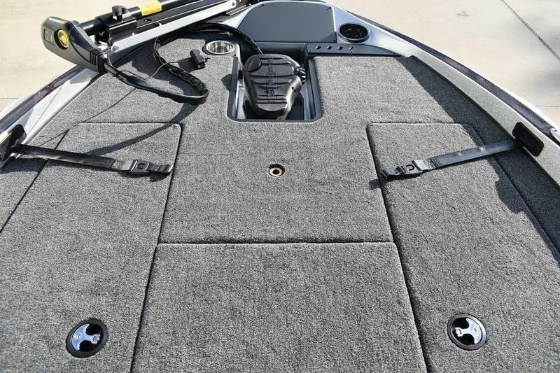 Slide: The Image of 2026 Triton 179 TrX boat deck with carpeted surface and fishing equipment. - 6