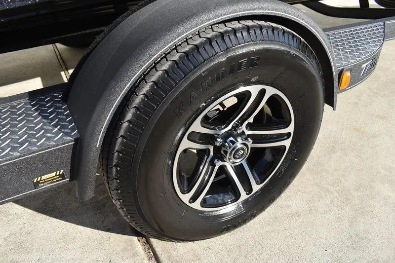 Slide: The Image of 2026 Triton 179 TrX trailer tire with alloy wheel on concrete surface. - 8