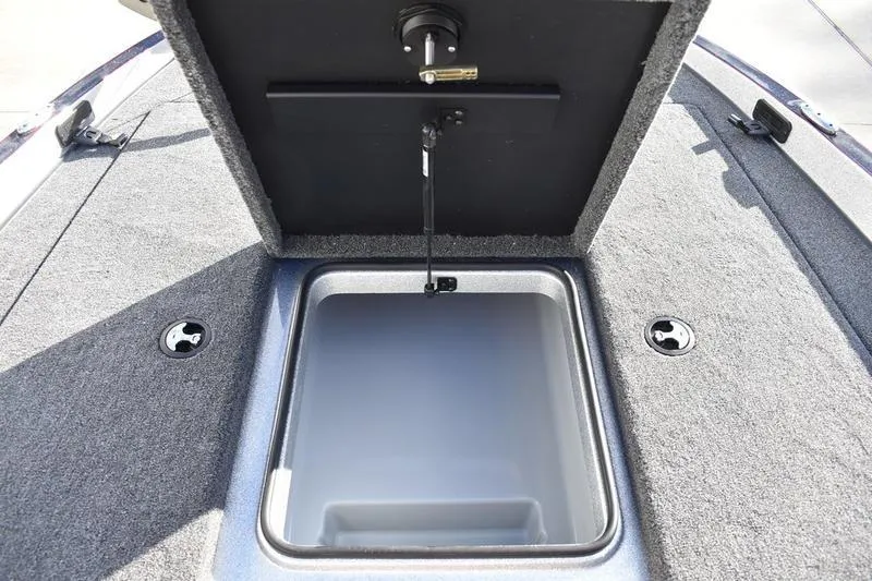 Slide: The Image of Open storage compartment on 2026 Triton 179 TrX boat, featuring carpeted interior. - 9