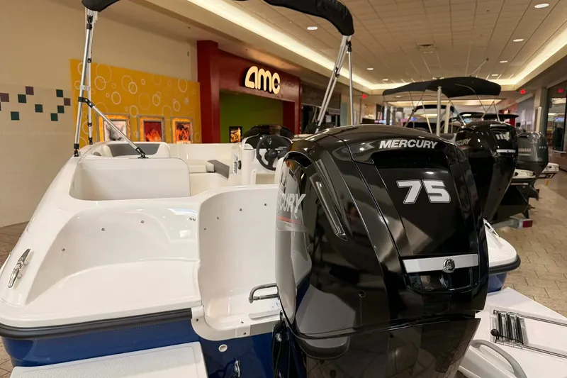 Slide: The Image of 2025 Bayliner Element E16 boat with Mercury 75 engine displayed indoors. - 6