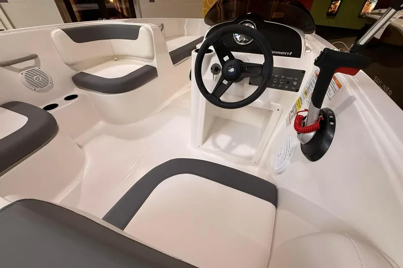 Slide: The Image of 2025 Bayliner Element E16 boat interior with steering wheel and seating. - 2