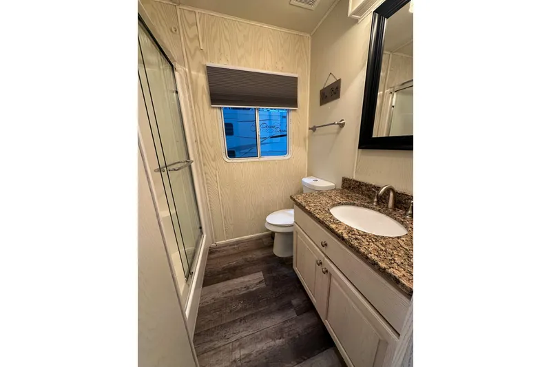 Slide: The Image of Compact bathroom in 2000 Sharpe 16x90 houseboat with granite countertop and shower. - 11