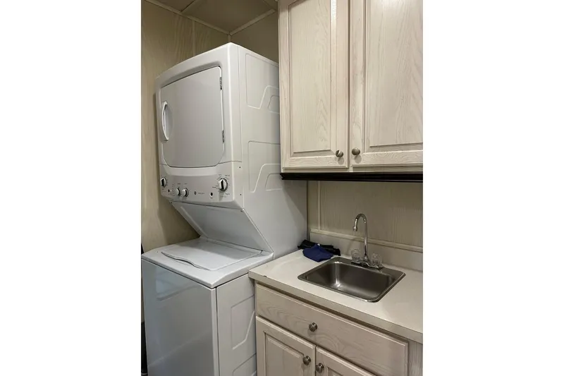 Slide: The Image of Stacked washer and dryer beside sink and cabinets in compact laundry area. - 12
