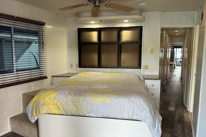 Slide: The Image of Bedroom interior of 2000 Sharpe 16x90 houseboat with bed, window, and ceiling fan. - 13