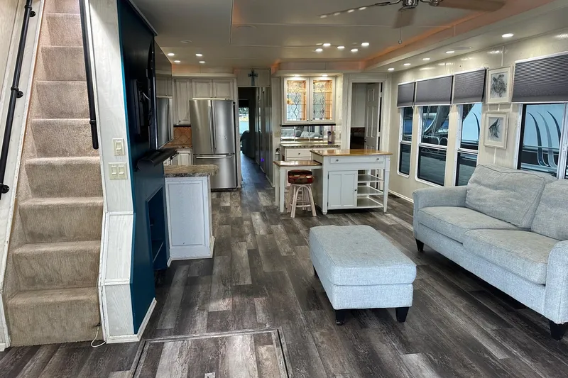 Slide: The Image of Modern houseboat interior with stylish decor, featuring a kitchen, staircase, and comfortable seating area. - 2