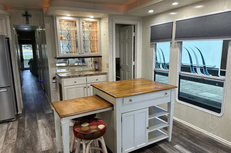 Slide: The Image of Modern kitchen interior in a 2000 Sharpe 16x90 houseboat with wood accents and ample lighting. - 5