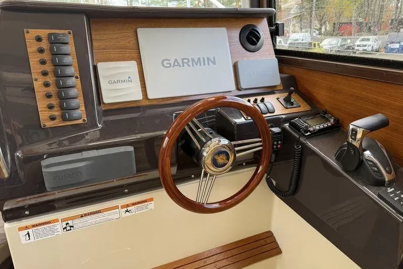 Slide: The Image of 2021 Ranger Tugs R-27 helm with Garmin navigation and wood accents. - 17