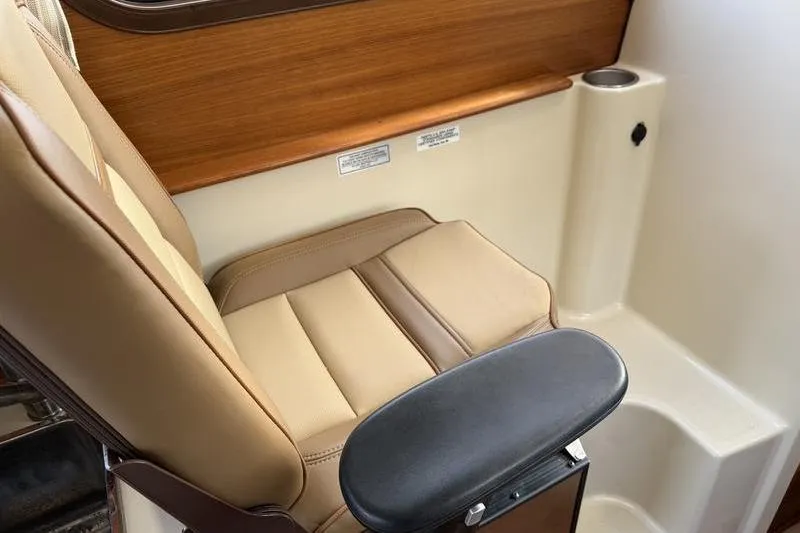 Slide: The Image of 2021 Ranger Tugs R-27 interior seat with beige upholstery and wooden accents. - 21