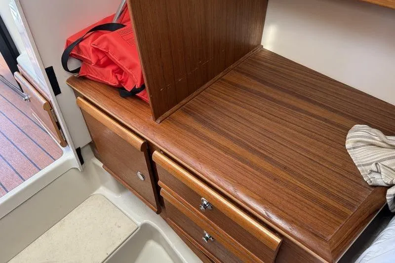 Slide: The Image of 2021 Ranger Tugs R-27 interior with wooden cabinetry and red life jacket. - 23