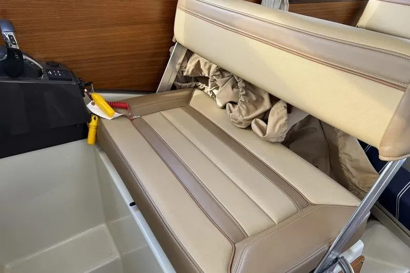 Slide: The Image of 2021 Ranger Tugs R-27 interior with beige leather seating and control panel. - 26