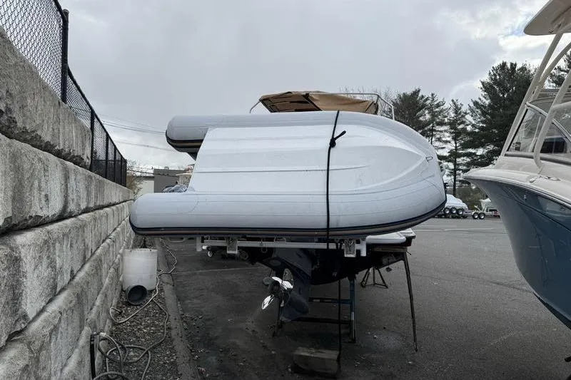 Slide: The Image of 2021 Ranger Tugs R-27 boat with inflatable dinghy on deck, parked outdoors. - 3