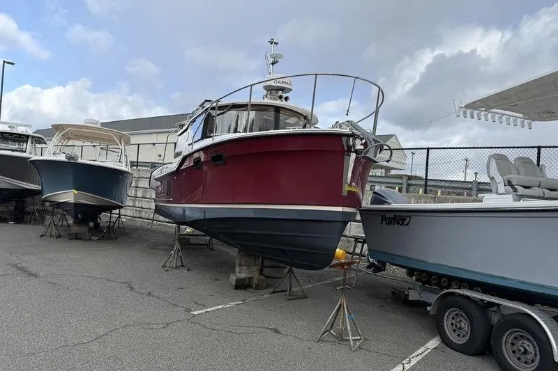 Slide: The Image of 2021 Ranger Tugs R-27 boat on stands in a marina storage area. - 4