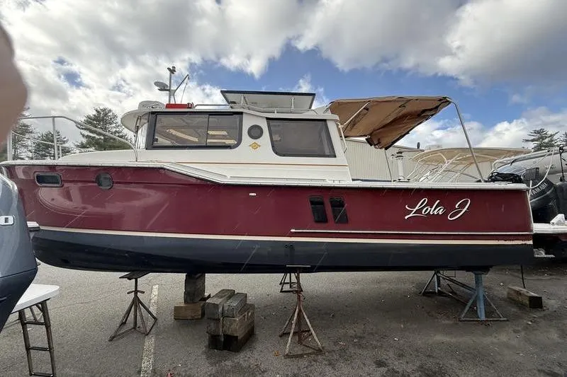 Slide: The Image of 2021 Ranger Tugs R-27 boat "Lola J" on stands, red and white exterior. - 8